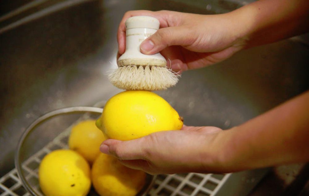 Размягчите парафиновый слой на лимоне под струёй тёплой воды, а затем снимите воск щёткой для овощей и фруктов